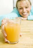 Woman holding fresh squeezed mango juice - x75748191