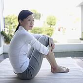 Stock Photo of Young woman sitting, hugging knees u17596814 - Search